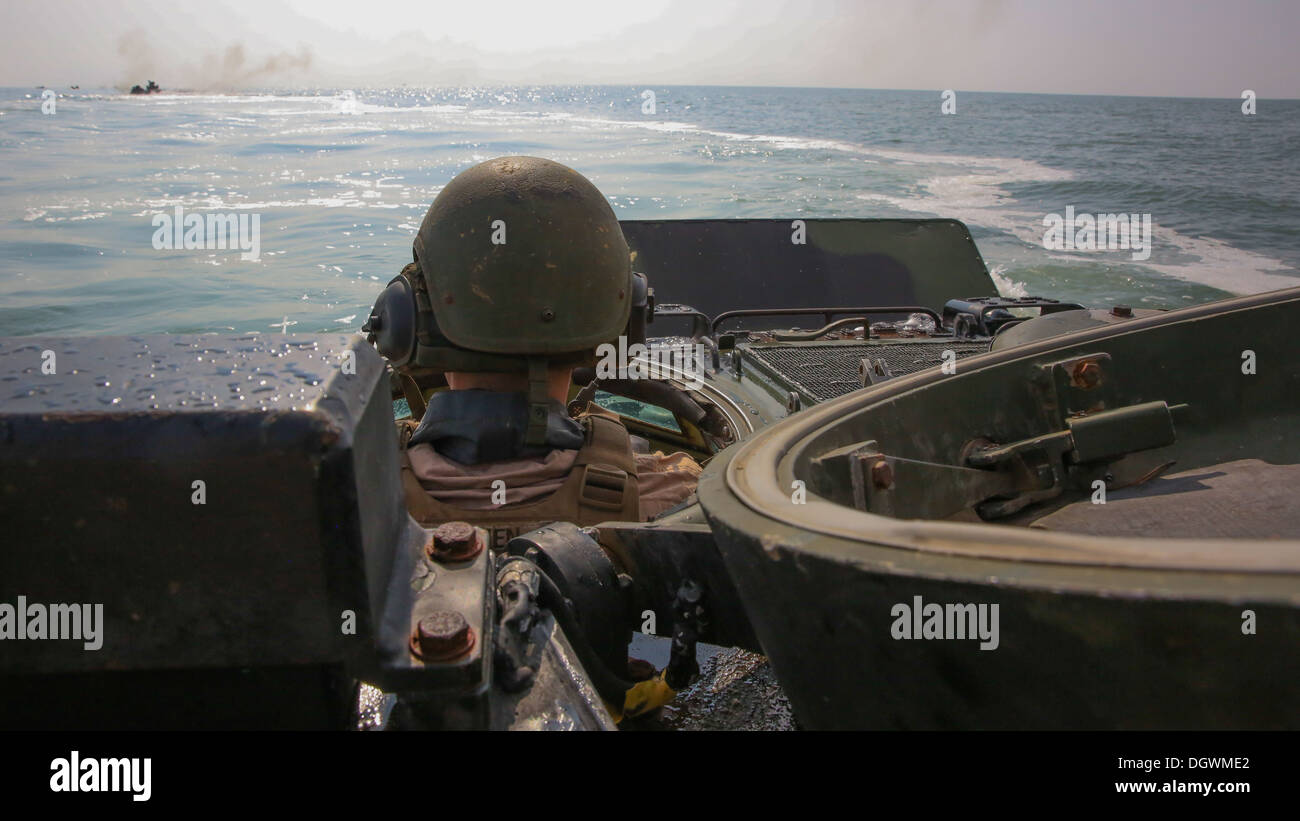 Lance Cpl. Christopher O'Brien, Crewchief mit 2. Assault Amphibian Battalion, 2. Marine-Division, folgt anderen Flugabwehrpanzer während einer amphibischen Operation am Onslow Beach an Bord der Marine Corps Base Camp Lejeune, 18. Oktober 2013. "Die amphibischen Operationen wir p Stockfoto