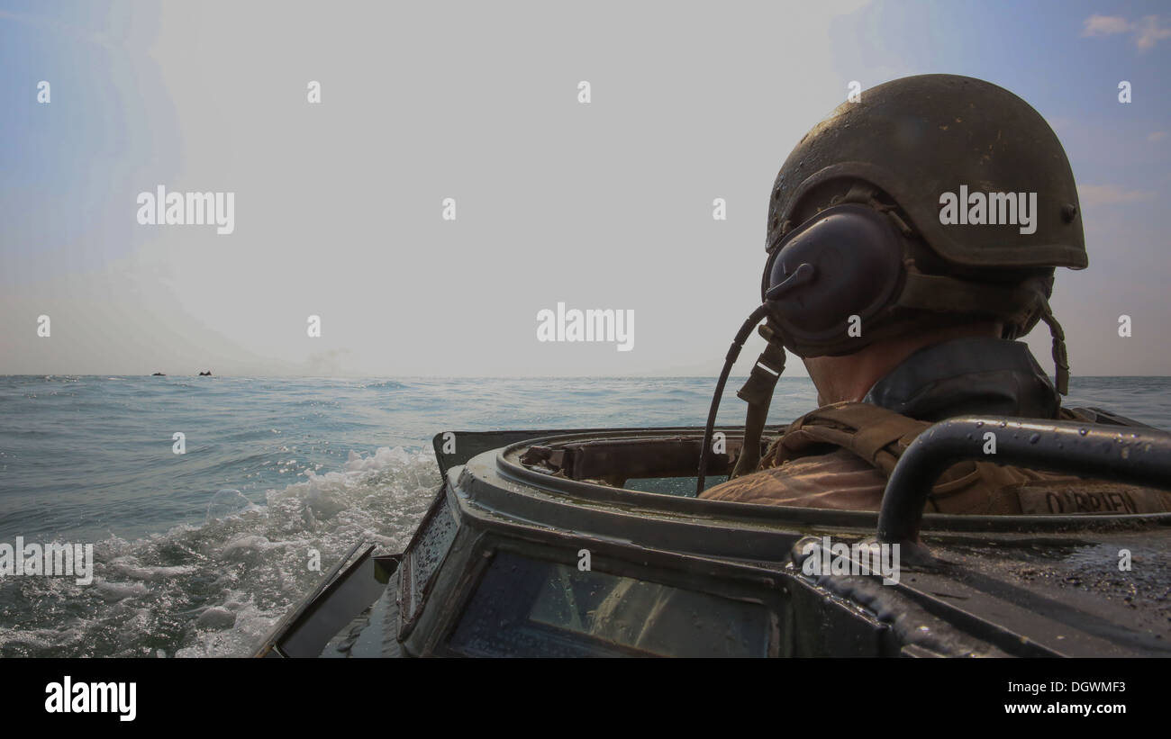 Lance Cpl. Christopher O'Brien, ein Crewchef mit 2. Assault Amphibian Battalion, 2. Marine-Division, folgt anderen Flugabwehrpanzer während einer amphibischen Operation am Onslow Beach an Bord der Marine Corps Base Camp Lejeune, 18. Oktober 2013. "Die amphibischen Operationen wir Stockfoto