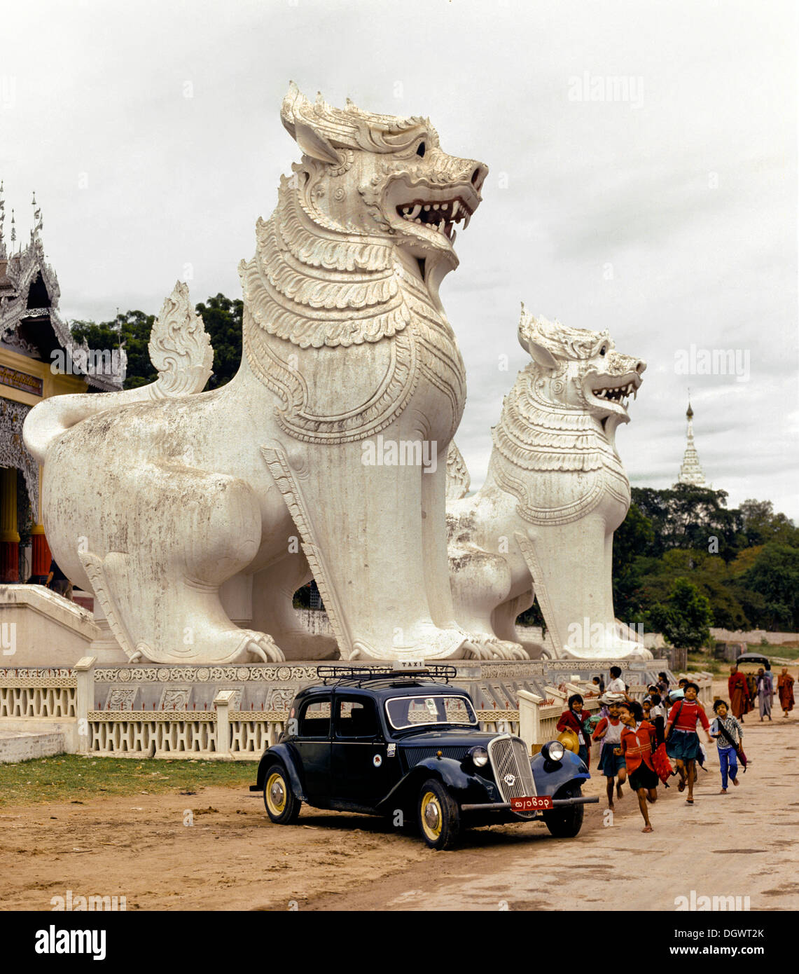 Chinthe Löwen auf dem Mandalay Hill, Oldtimer und die Kinder spielen an der Front, Mandalay-Division, Mandalay, Birma, Myanmar Stockfoto