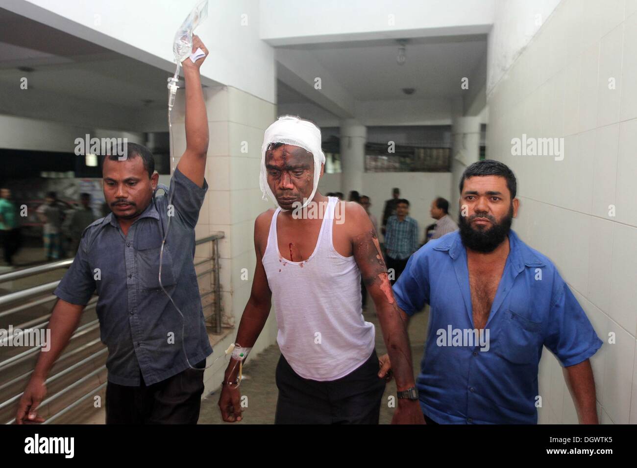 Dhaka, Bangladesch. 26 Okt, 2013. Kollege hilft Alal, ein Fahrer eines auto Rikscha, zu einem Operationssaal in Dhaka Medical College Hospital, nachdem er in einem Bombenattentat in Dhaka, Oktober 26, 2013 verletzt wurde. Pro-Streik Aktivisten warfen rohe Bomben, mutwillig zerstört und das Feuer auf mindestens 13 Fahrzeuge und mehr als 50 Menschen in Dhaka verletzt wurden. Bangladesh Nationalist Party (BNP) und die Verbündeten für drei Tag landesweite Streik von Sonntag genannt wird, eine geschäftsführende Regierung fordert, die lokalen Medien berichtet. Stockfoto