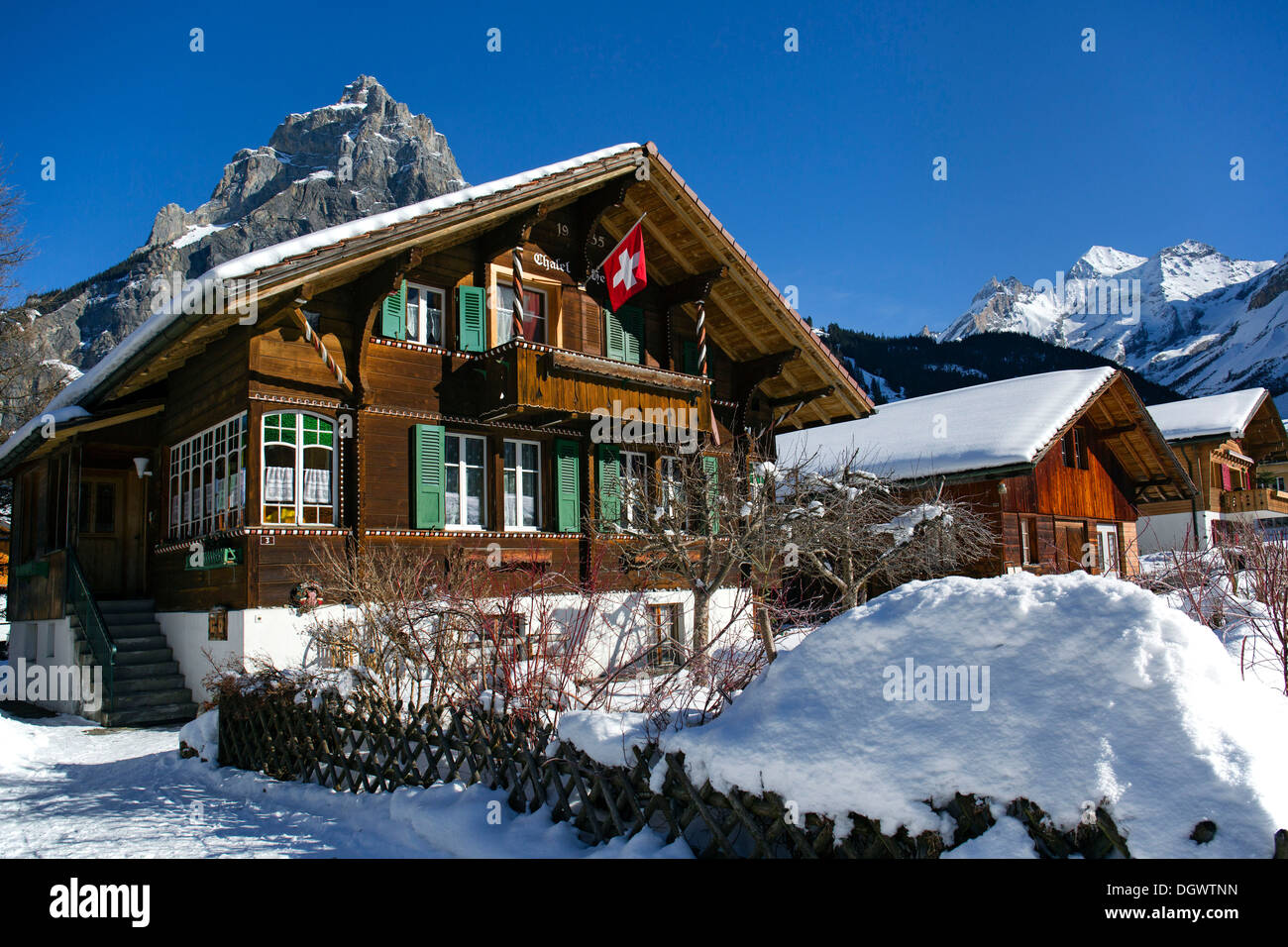 Chalet mit einer Schweizer Flagge, Bire Berg auf der linken Seite, Blueemlisalp massiv auf die richtige, Winter Landschaft, Berner Alpen Stockfoto