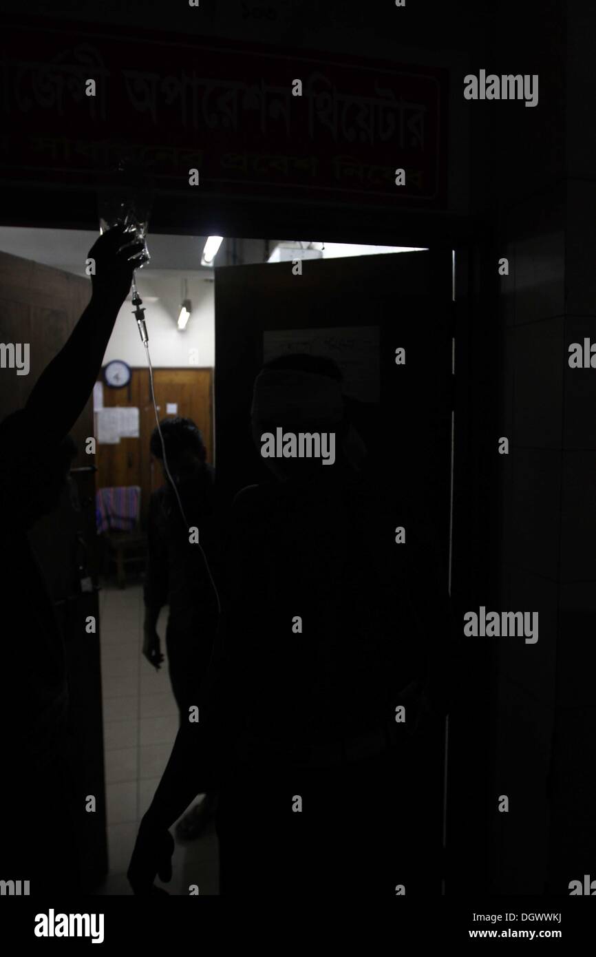 Dhaka, Bangladesch. 26 Okt, 2013. Ein Kollege hilft Alal, ein Fahrer eines auto Rikscha, zu einem Operationssaal in Dhaka Medical College Hospital, nachdem er in einem Bombenattentat in Dhaka, Oktober 26, 2013 verletzt wurde. Pro-Streik Aktivisten warfen rohe Bomben, mutwillig zerstört und das Feuer auf mindestens 13 Fahrzeuge und mehr als 50 Menschen in Dhaka verletzt wurden. Bangladesh Nationalist Party (BNP) und die Verbündeten für drei Tag landesweite Streik von Sonntag genannt, fordern Sie eine geschäftsführende Regierung, lokale Medien berichteten Stockfoto