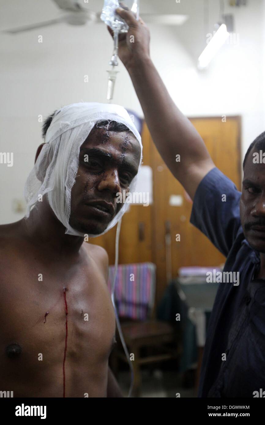 Dhaka, Bangladesch. 26 Okt, 2013. Ein Kollege hilft Alal, ein Fahrer eines auto Rikscha, zu einem Operationssaal in Dhaka Medical College Hospital, nachdem er in einem Bombenattentat in Dhaka, Oktober 26, 2013 verletzt wurde. Pro-Streik Aktivisten warfen rohe Bomben, mutwillig zerstört und das Feuer auf mindestens 13 Fahrzeuge und mehr als 50 Menschen in Dhaka verletzt wurden. Bangladesh Nationalist Party (BNP) und die Verbündeten für drei Tag landesweite Streik von Sonntag genannt, fordern Sie eine geschäftsführende Regierung, lokale Medien berichteten Stockfoto