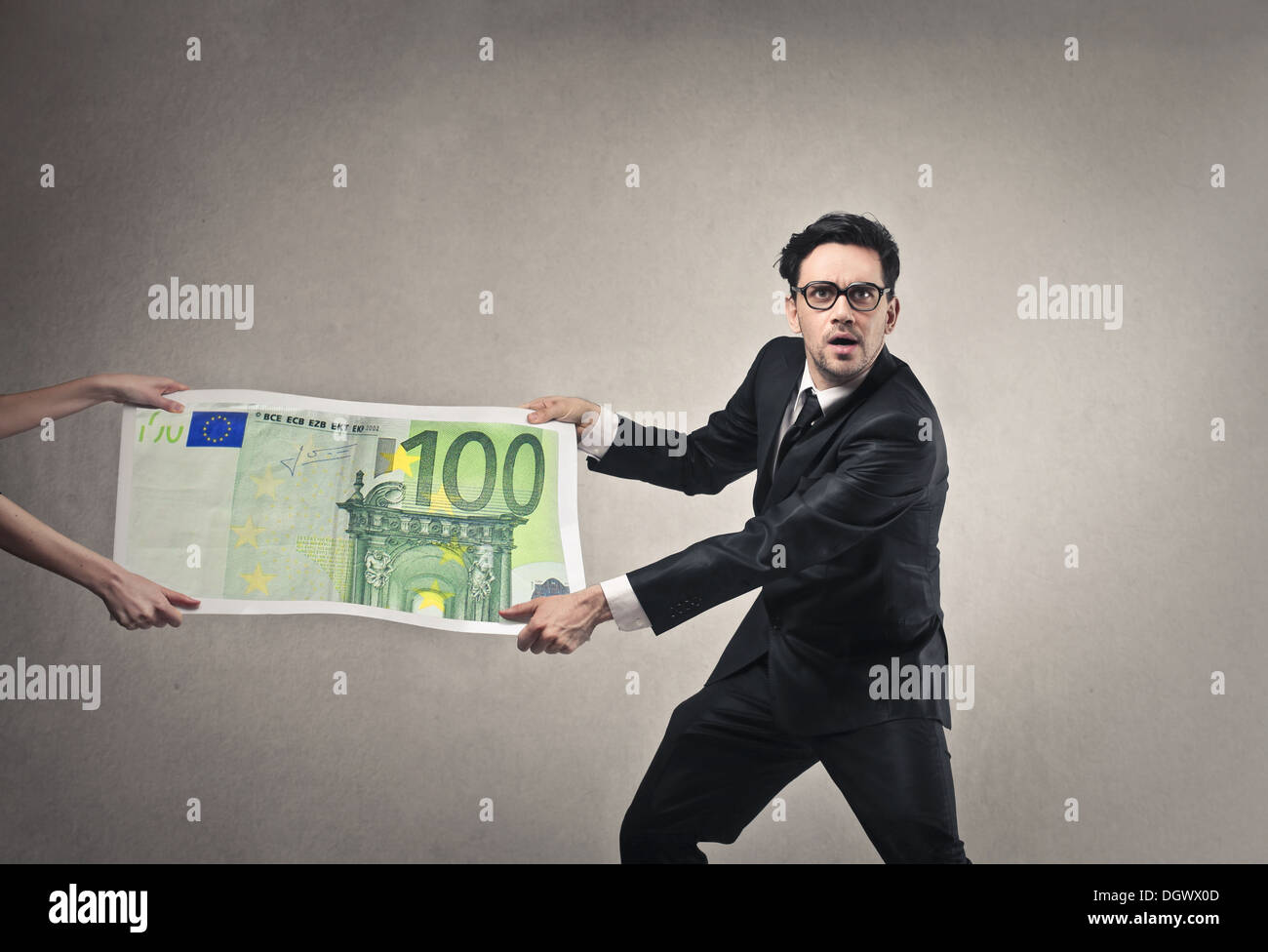 Geschäftsmann, ziehen weg von einem anderen Mann eine riesigen hundert - Euro-banknote Stockfoto