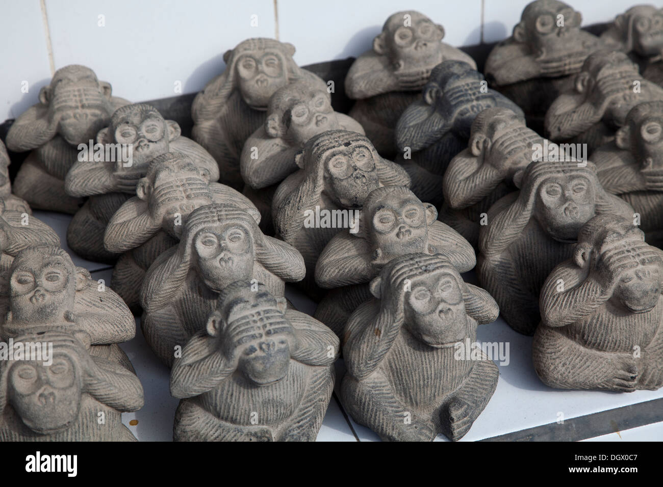 Graue Affen hören sehen Gespräch sagen Geschenk Dekoration Spielzeugladen Bali Indonesien Souvenirs kaufen verkaufen Touristen hören sagen siehe Stein sprechen sprechen Stockfoto
