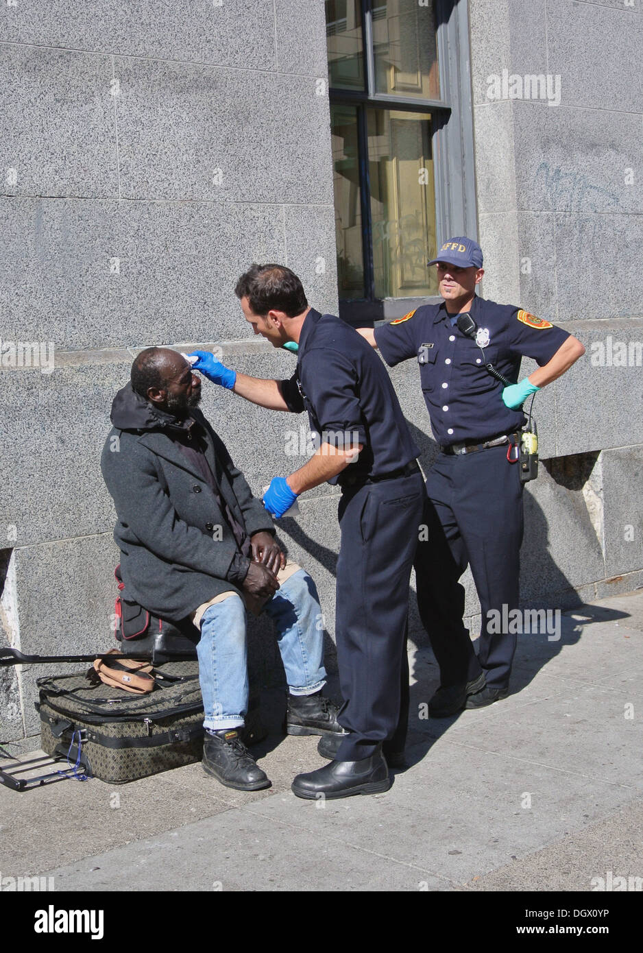 Polizisten in San Francisco leisten erste Hilfe für SCHWARZE Obdachlose im Tenderloin Stockfoto