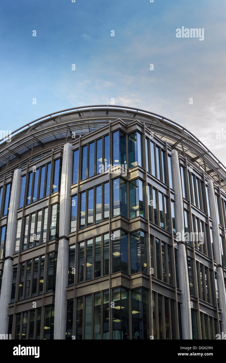 Ecke eines kommerziellen Büros mit starken vertikalen Elementen vor blauem Himmel diesig Stockfoto