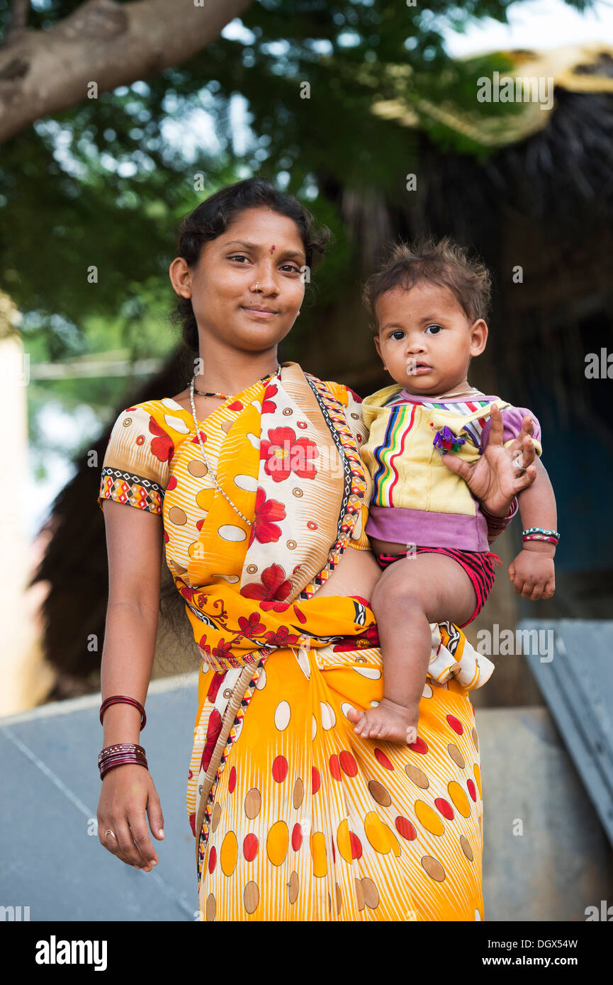 Junge niedrigere Kaste indischen Teenager-Mädchen hält ihr kleines Mädchen. Andhra Pradesh, Indien Stockfoto