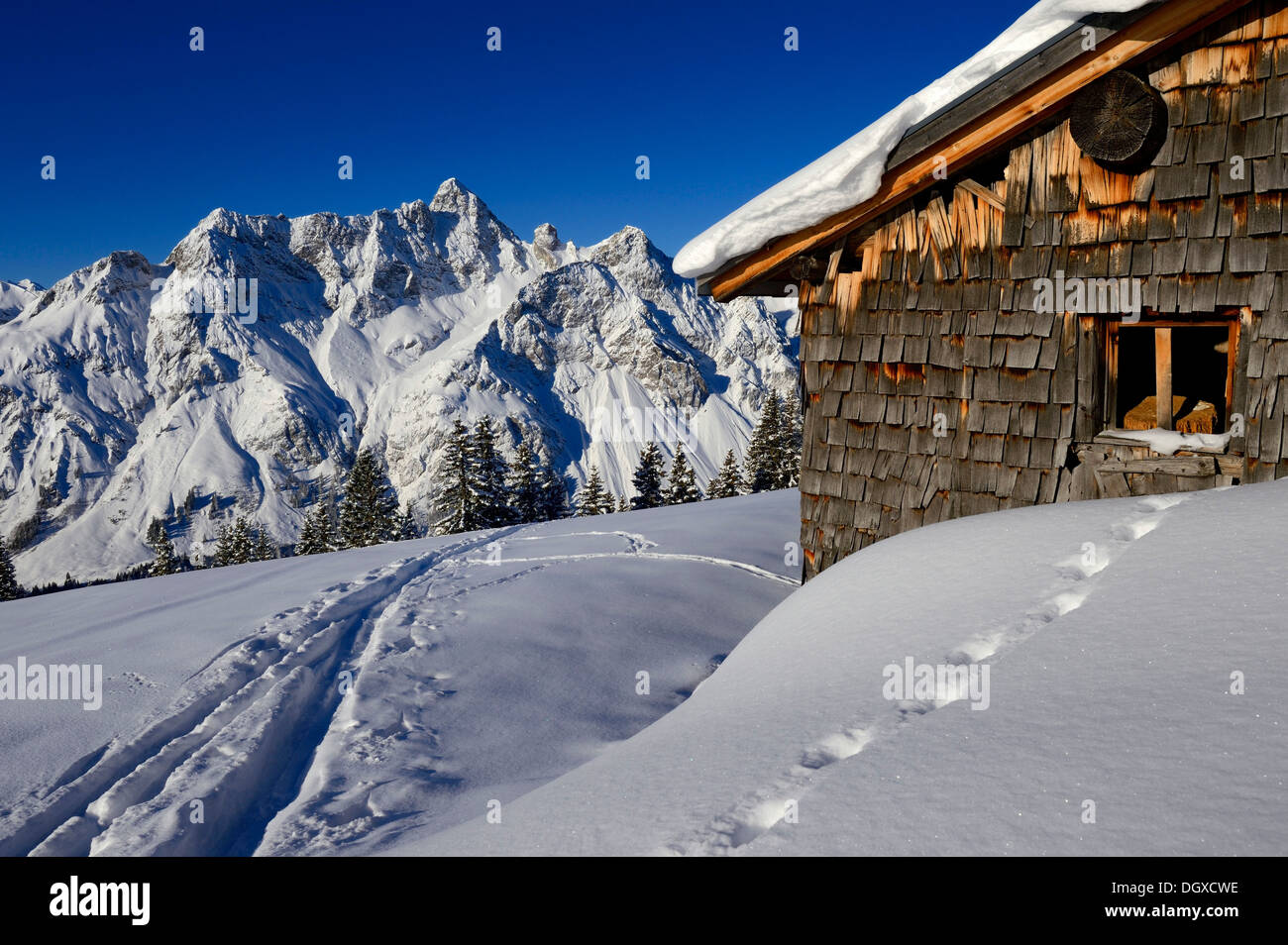Snowbound Vordere Uentschenalpe Hütte mit eine Schipiste und der Gipfel des Mt Toblermannskopf, Baad, Kleinwalsertal, Vorarlberg Stockfoto