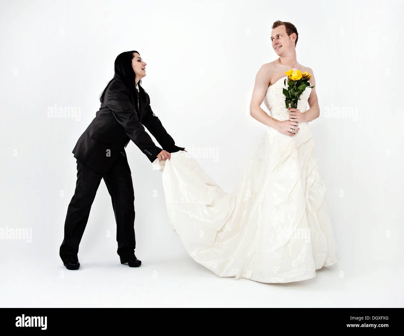 Braut trägt einen Anzug halten Sie den Zug von einem Hochzeitskleid  getragen von dem Bräutigam, Austausch von Hochzeit Kleidung, Österreich  Stockfotografie - Alamy