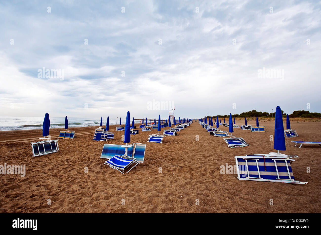 Gefaltet, Liegestühle und Sonnenschirme am Strand am Meer mit Regenwolken, Cavallino, Jesolo, Venedig, Italien Stockfoto