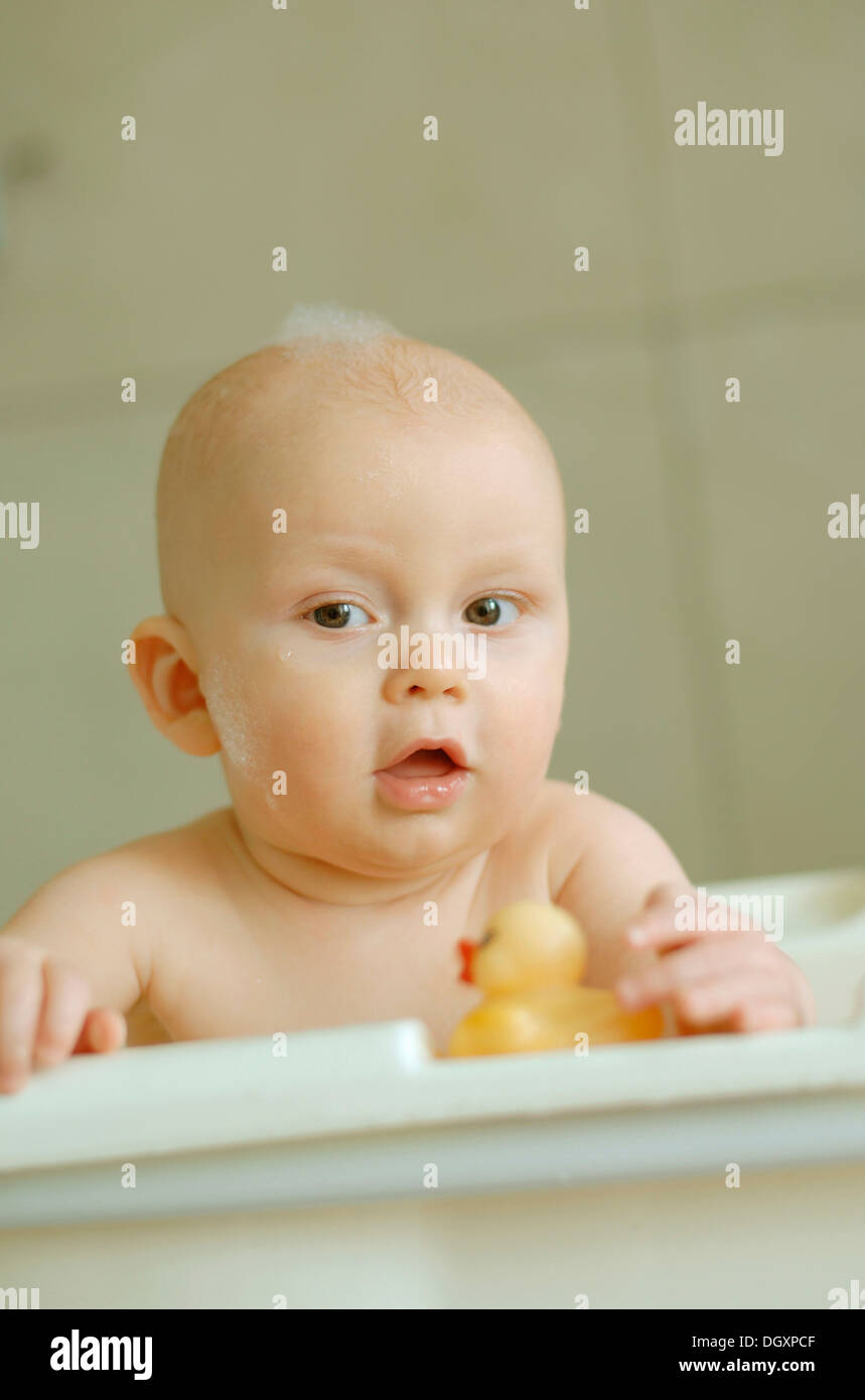 Baby in einem Bad mit Schaum auf dem Kopf Stockfoto