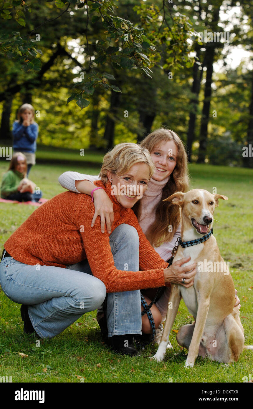 Mutter und drei Töchter mit einem Hund in einem park Stockfoto