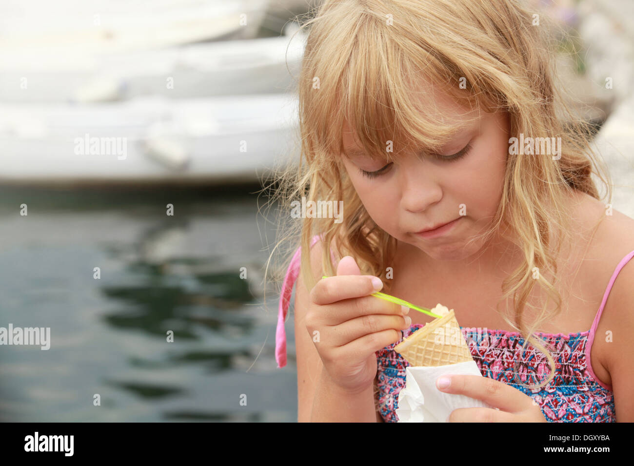 Kleines blondes Mädchen isst Eis. Outdoor-Sommer-Porträt Stockfoto