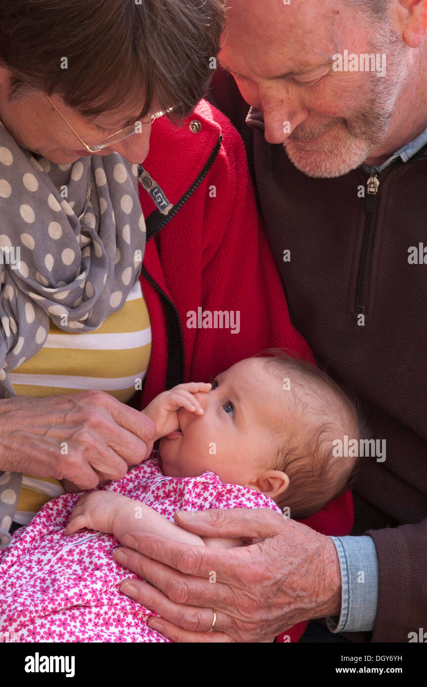 Großeltern halten und streicheln ihre kleine Enkelin Stockfoto