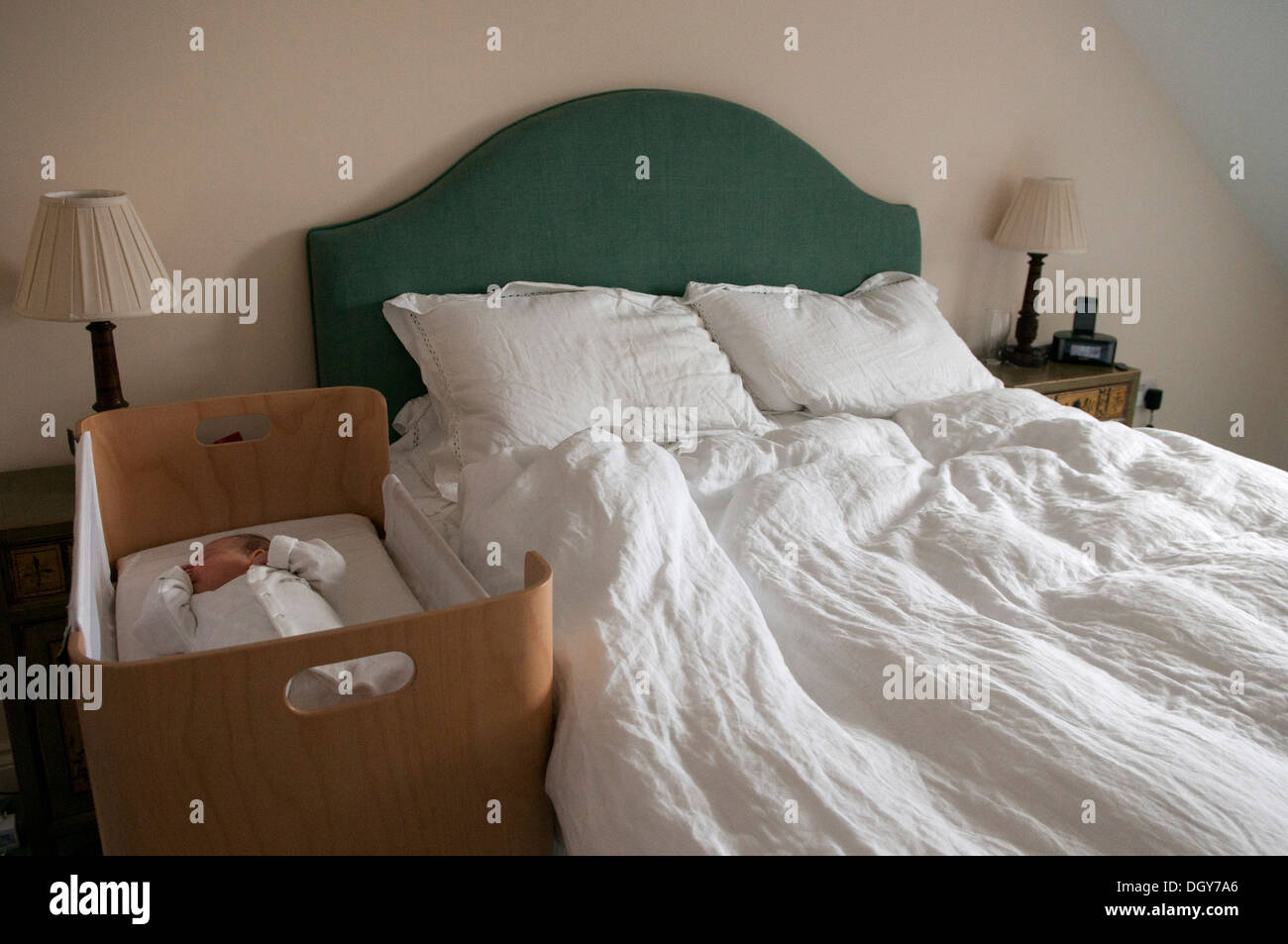 Kleines Baby schlafend in ihrem Kinderbett neben dem leeren Bett der Eltern Stockfoto