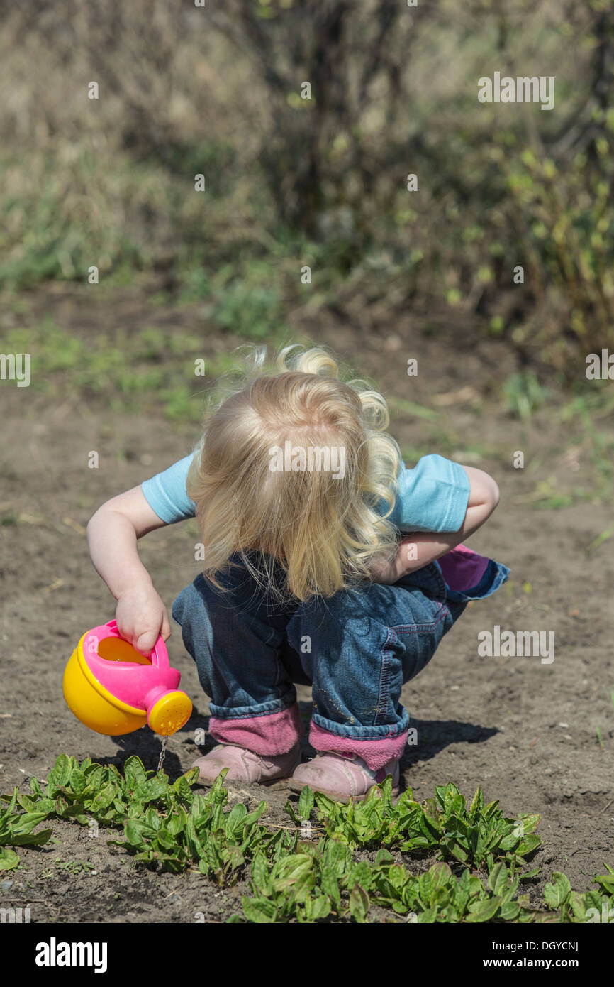 Mädchen Bewässerung von Pflanzen mit ihrer Gießkanne Stockfoto