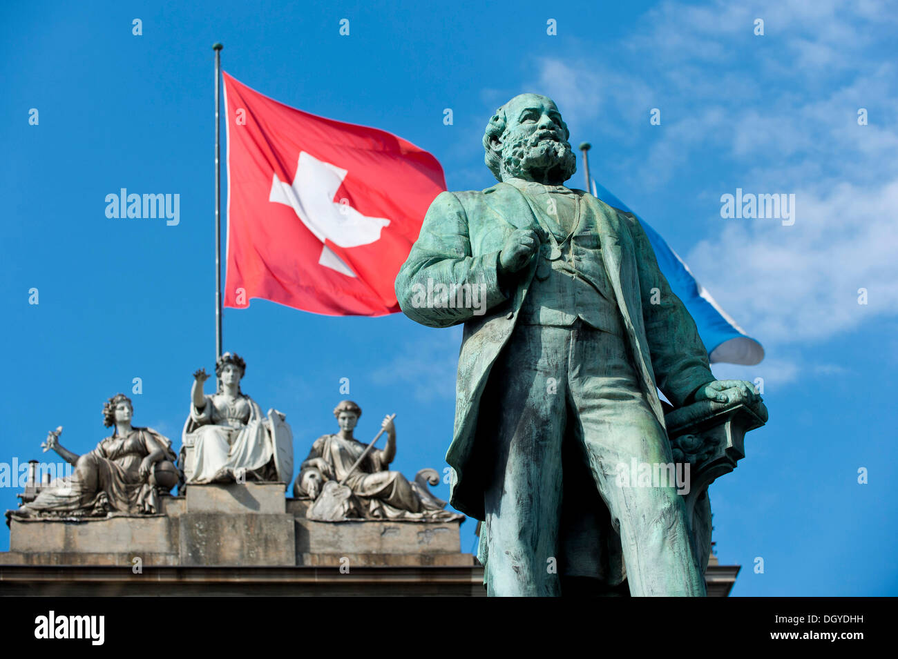 Schweizer Flagge hinter der Statue von Alfred Escher, Pionier Schweizer Politiker, Unternehmer und Eisenbahn, von Richard Stockfoto
