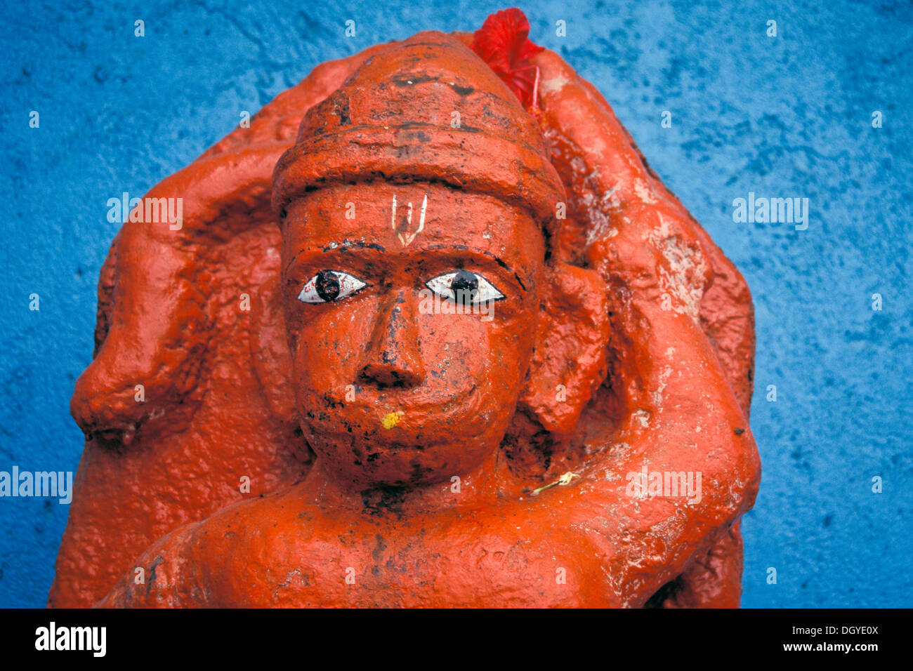 Hanuman, ein Affe-wie humanoid Hindu-Gottheit des Ramayana, orange Statue vor einer blauen Wand, Nasik oder Nashik, Maharashtra Stockfoto