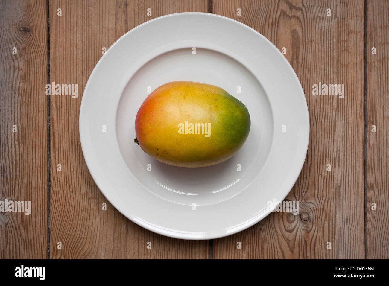 Mango auf Teller legen auf Holztisch Stockfoto