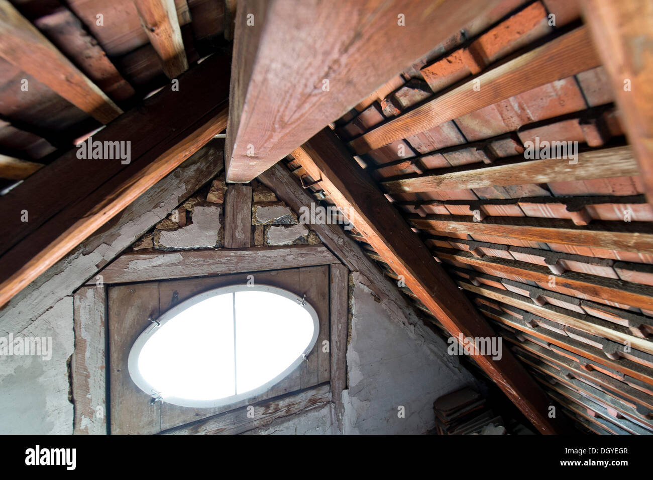 Ein ovales Fenster, Holzbalken, Dachboden, Holzdach eines alten Gebäudes, Stuttgart, Baden-Württemberg Stockfoto