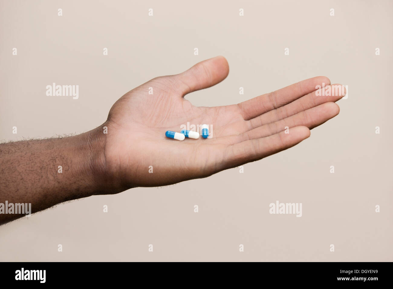 Mann, der aus drei Drogen Kapseln Stockfoto
