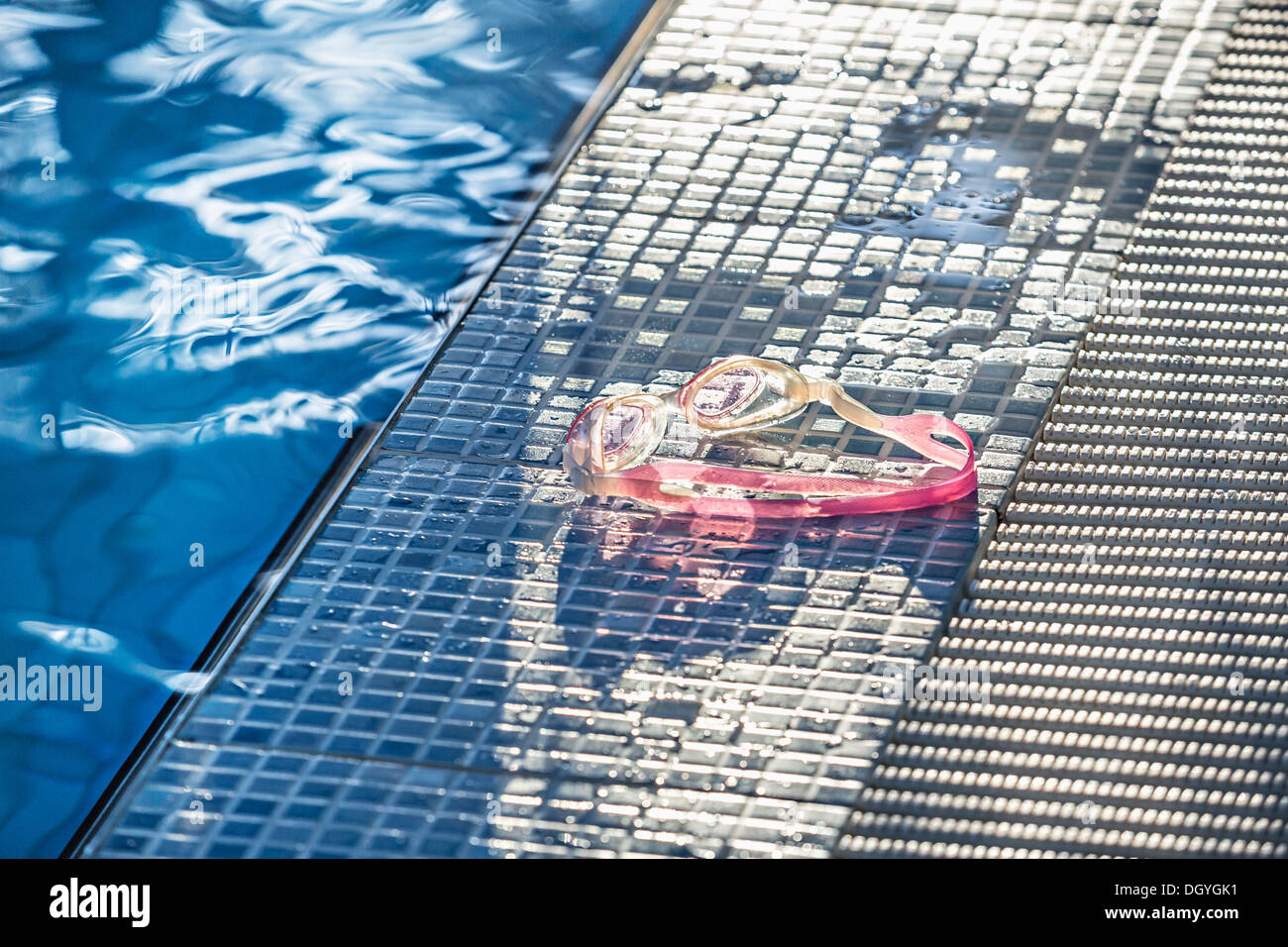 Sonnenlicht auf ein paar Swimming goggles am Rande eines Swimmingpools Stockfoto