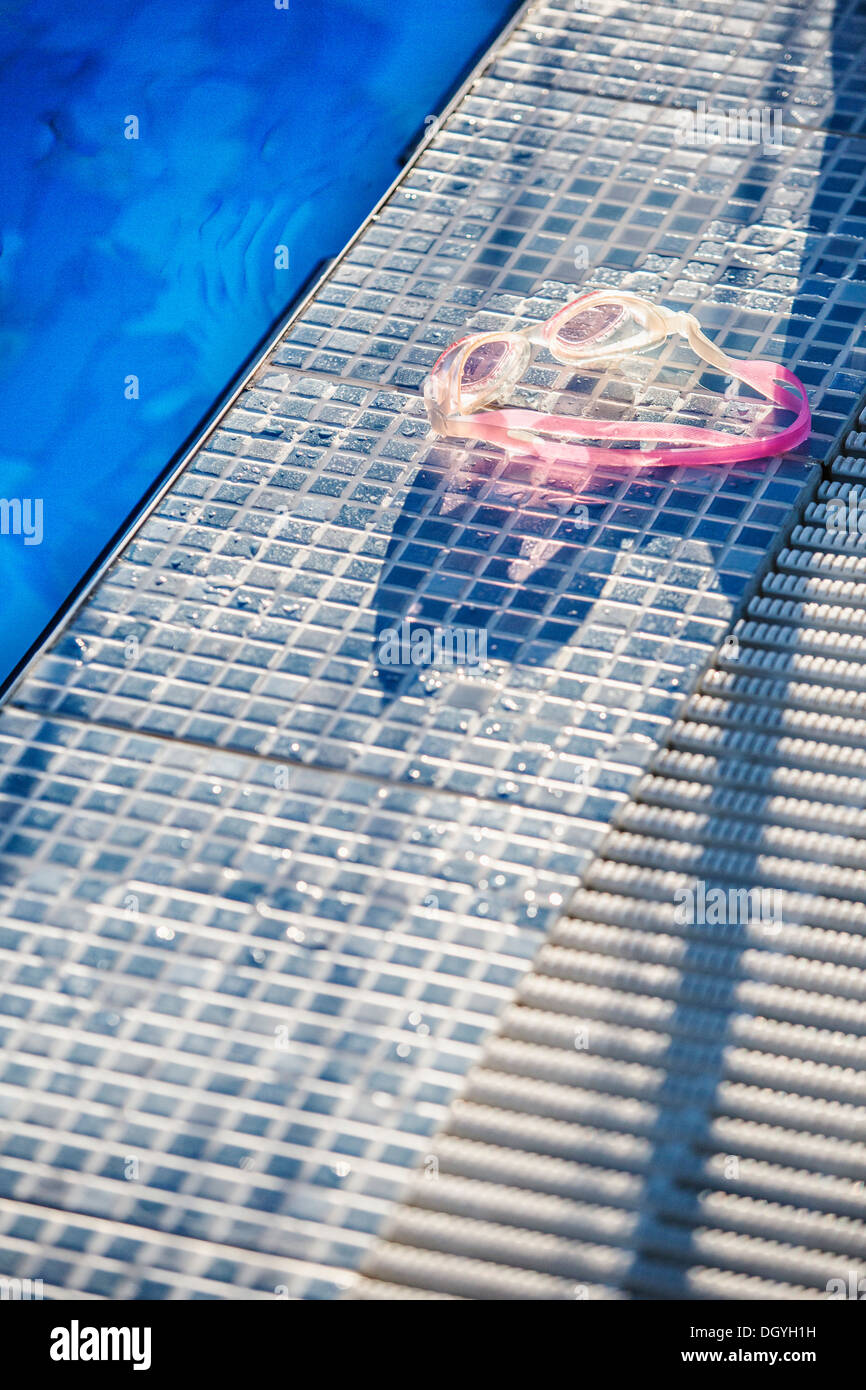 Sonnenlicht auf ein paar Swimming goggles am Rande eines Swimmingpools Stockfoto