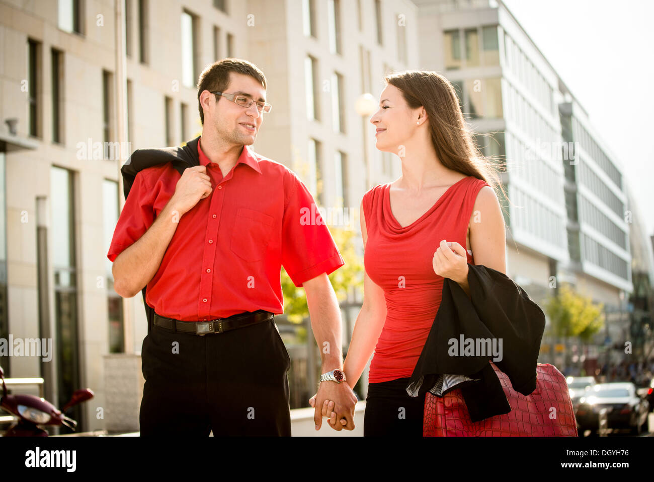 Junge lächelnde Geschäftsleute in rot die walking Street nach ihrer Arbeit Stockfoto