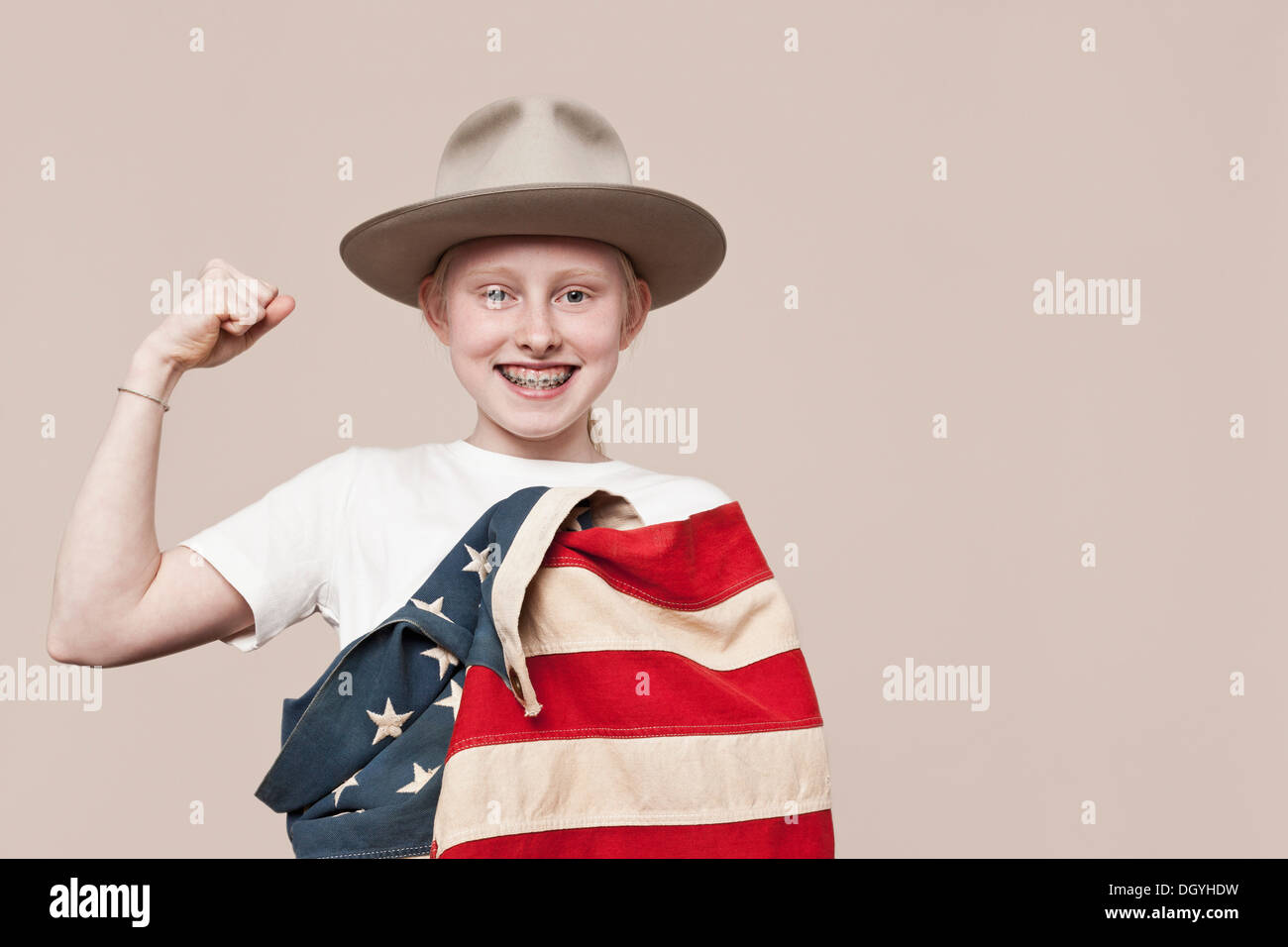 Ein lächelndes Mädchen einen Ranger Hut in eine amerikanische Flagge gehüllt und eine Faust machen Stockfoto