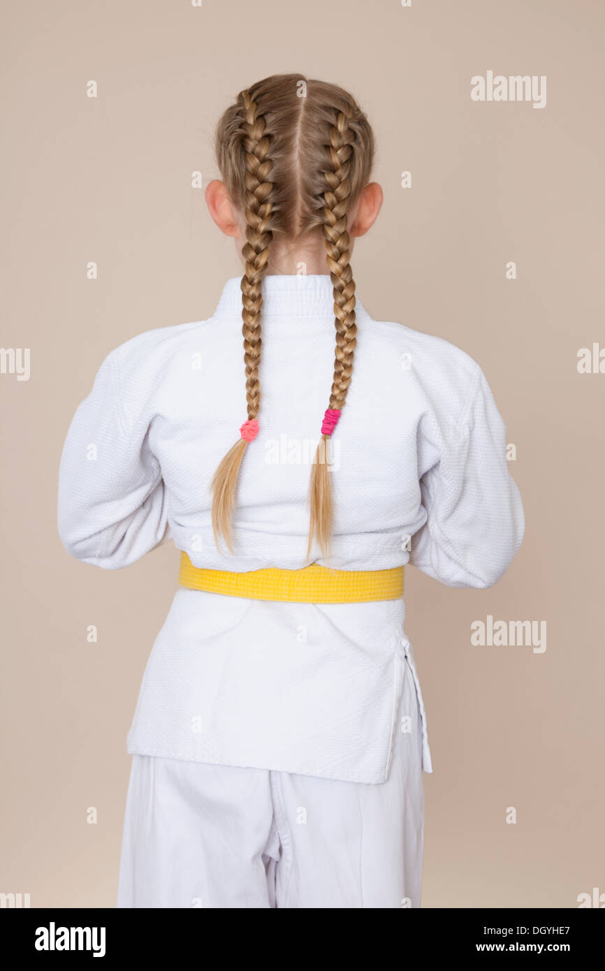 Ein Mädchen trägt Martial-Arts-uniform mit gelben Gürtel, Rückansicht Stockfoto