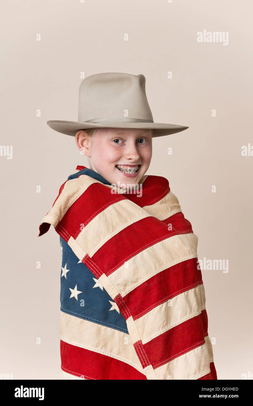 Ein lächelndes Mädchen einen Ranger Hut und eingehüllt in eine amerikanische Flagge Stockfoto