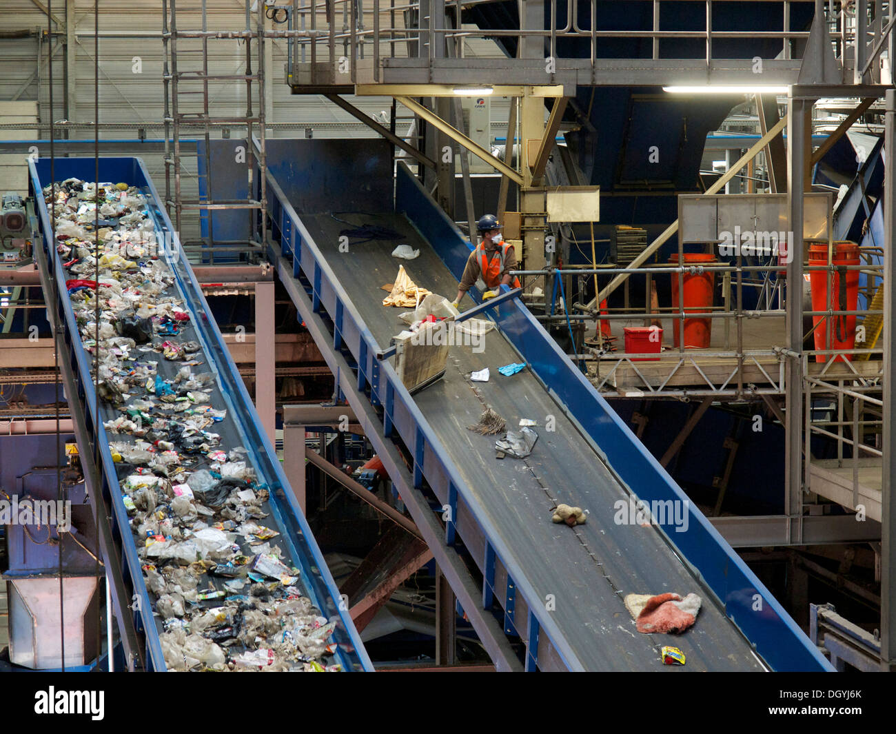 Mann im Hausmüll recycling-Anlage sortieren Müll auf Förderband von hand. Stockfoto