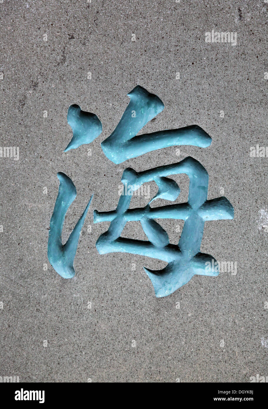 Es ist ein Foto von einem traditionellen chinesischen Schriftzeichen bedeutet Ozean oder Meer. Es ist in blauer Farbe auf eine graue Wand Stockfoto