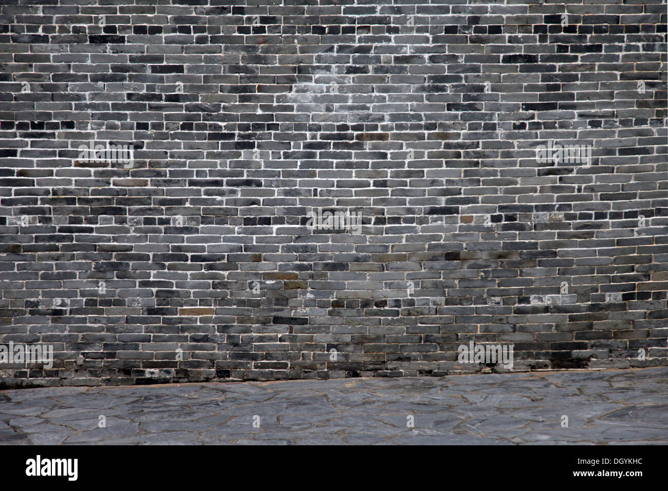 Es ist ein Foto von einer Wand aus flachen Steinen oder Ziegelsteinen in dunkler Farbe. Es verfügt über einen alten asiatischen Stil. Es ist einfach und Zen. Stockfoto
