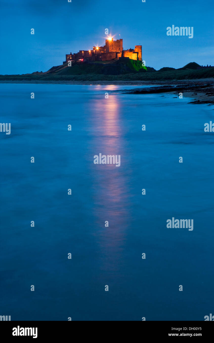 Bamburgh Castle beleuchtet in der Abenddämmerung, Bamburgh, Northumberland, England, Vereinigtes Königreich Stockfoto