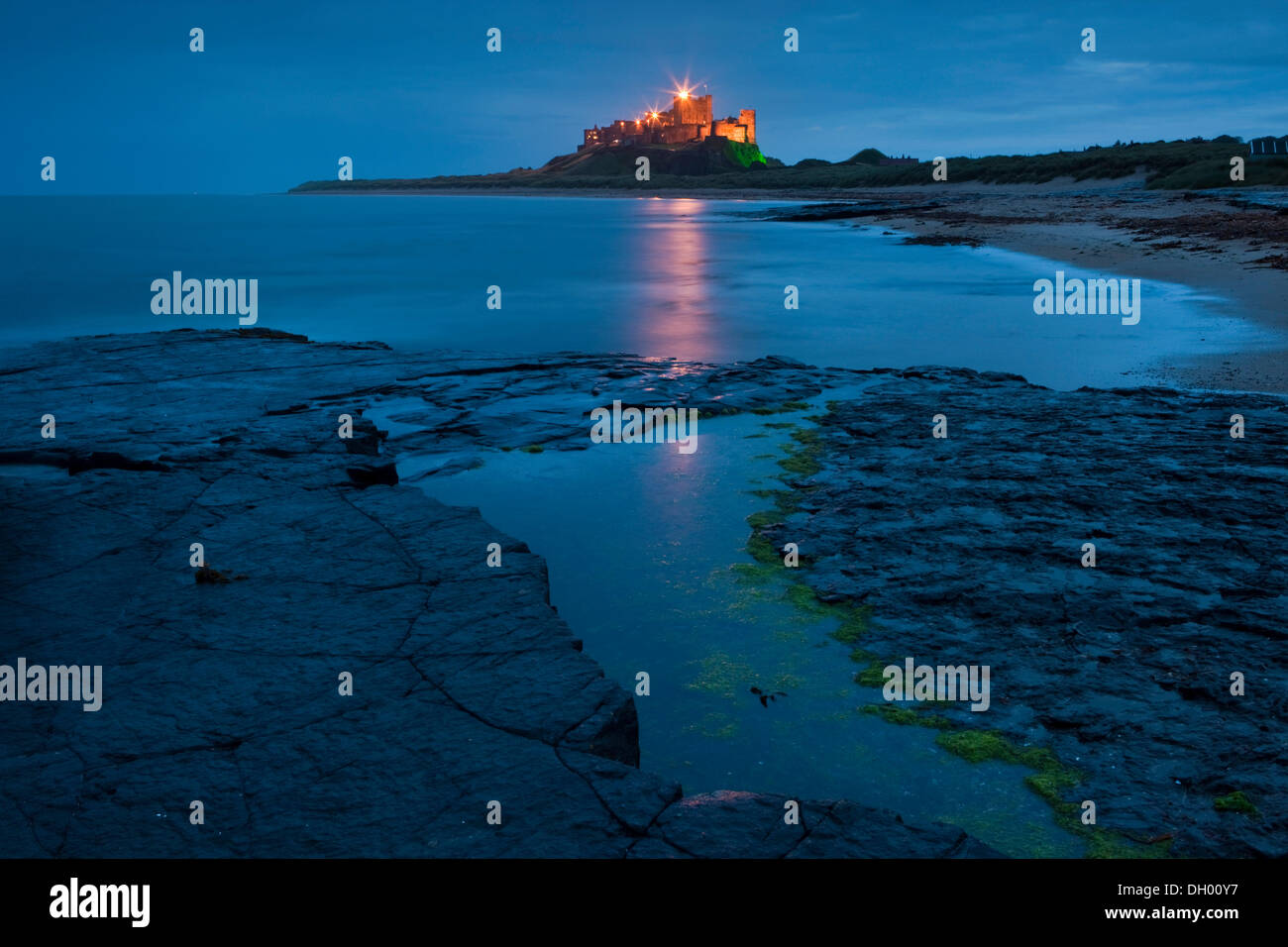 Bamburgh Castle beleuchtet in der Abenddämmerung, Bamburgh, Northumberland, England, Vereinigtes Königreich Stockfoto