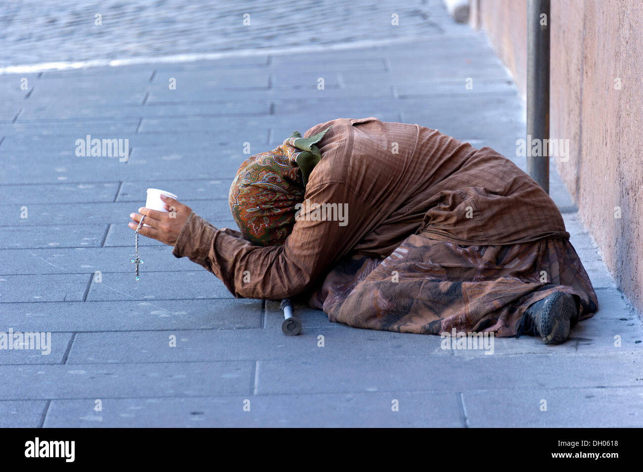 Bettlerin, die mit einem Plastikbecher in einer Straße der Altstadt, Rom, Latium, Italien Stockfoto