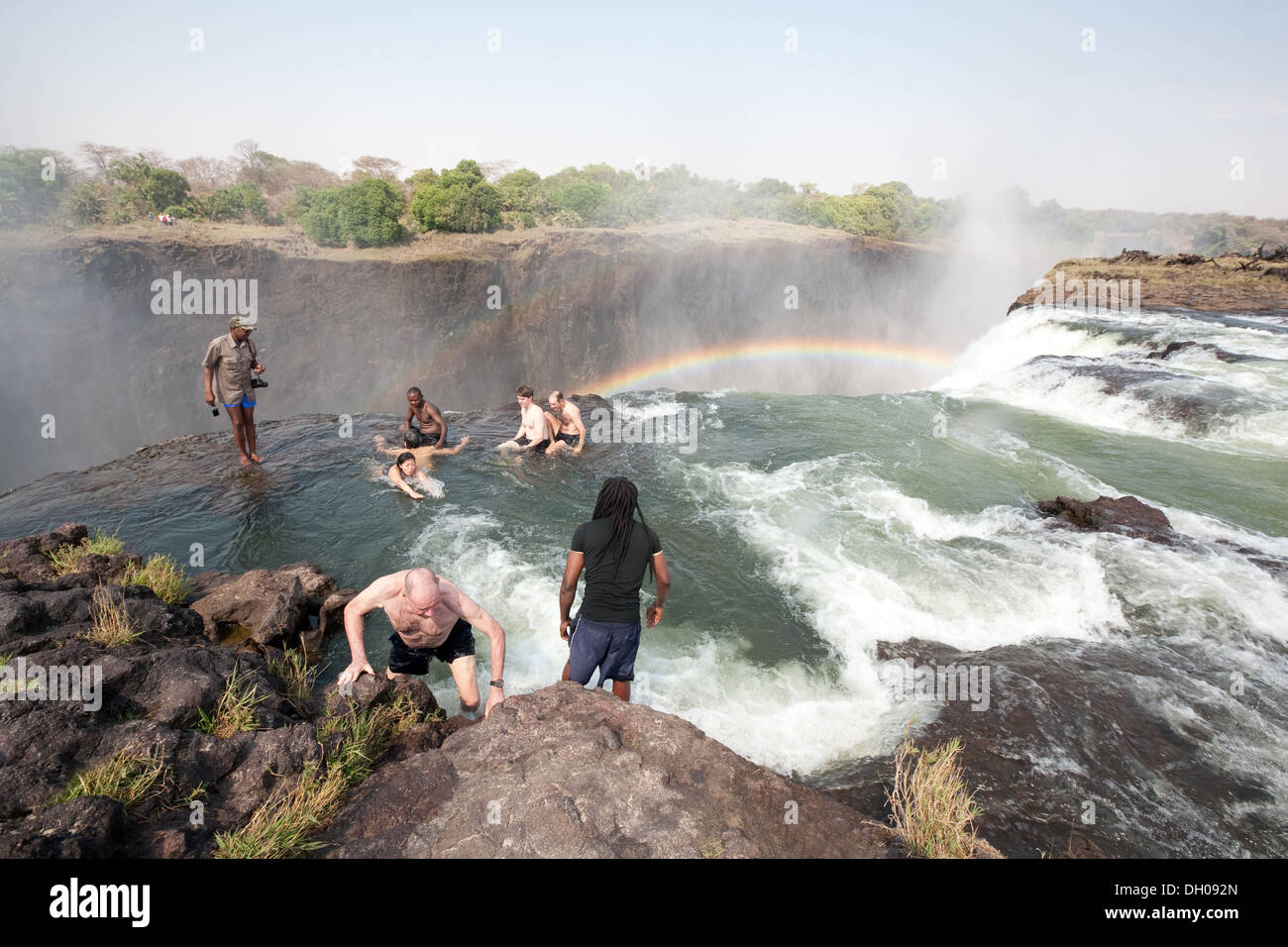 Touristen, die das Schwimmen im Pool Devils am Rande von Victoria Falls, Sambia Seite, Afrika Stockfoto