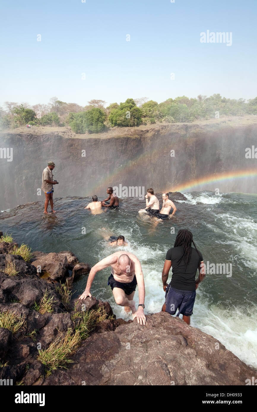 Devils Pool Victoria Falls; Sambia Side, Menschen auf einem Abenteuer-Urlaub Schwimmen am Rande der Wasserfälle im Devil's Pool, Sambia Africa Stockfoto