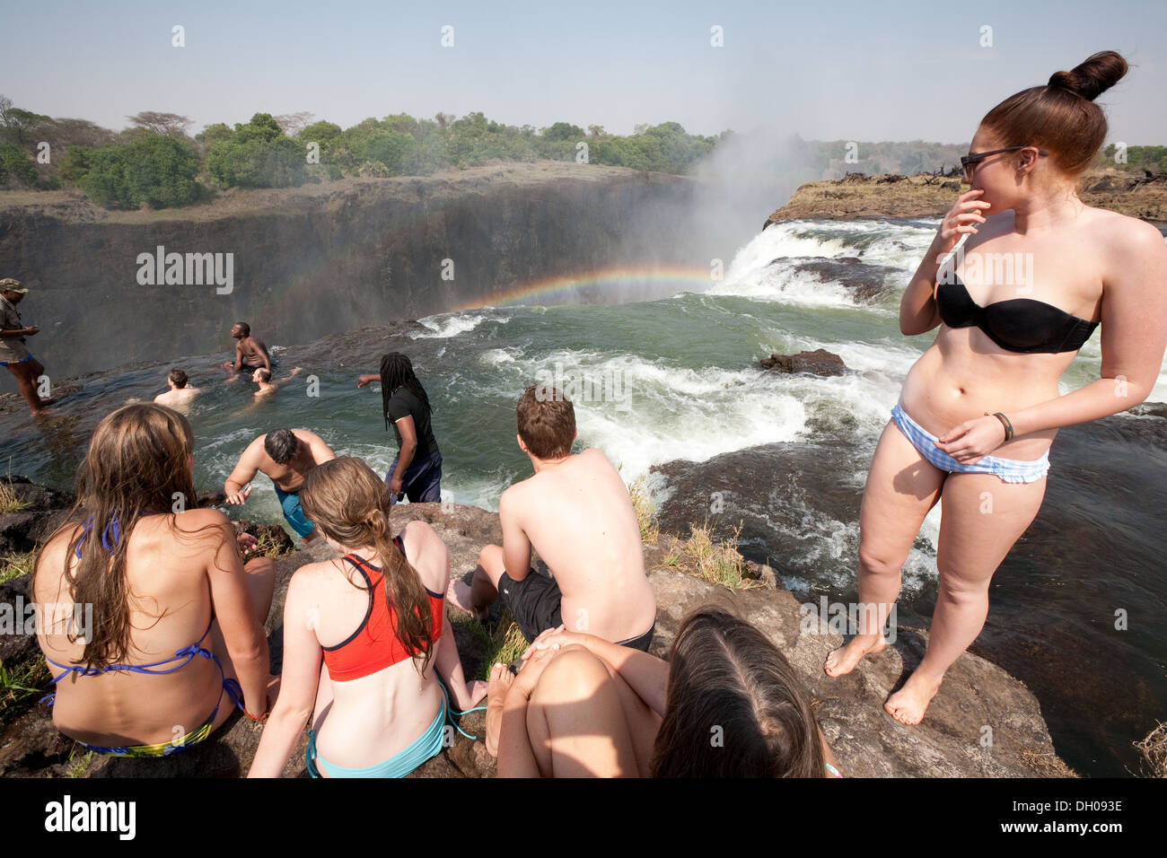 Touristen im Devils Pool am Rande der Victoriafälle, Insel Livingstone, Sambia Afrika Stockfoto