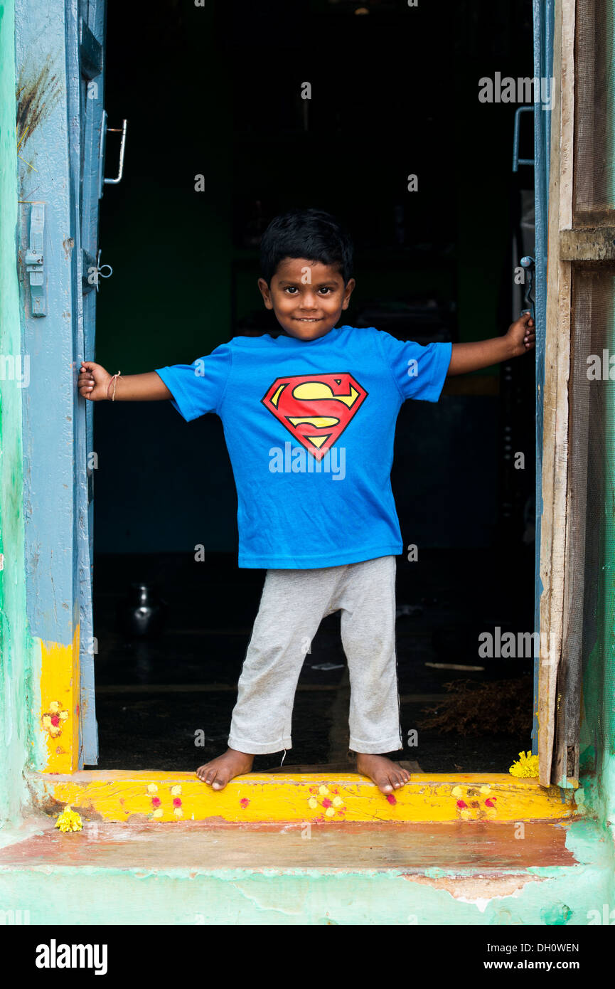 Jungen tragen ein Superman-t-Shirt-steht in der Tür seines Hauses in einem indischen Dorf. Andhra Pradesh, Indien Stockfoto