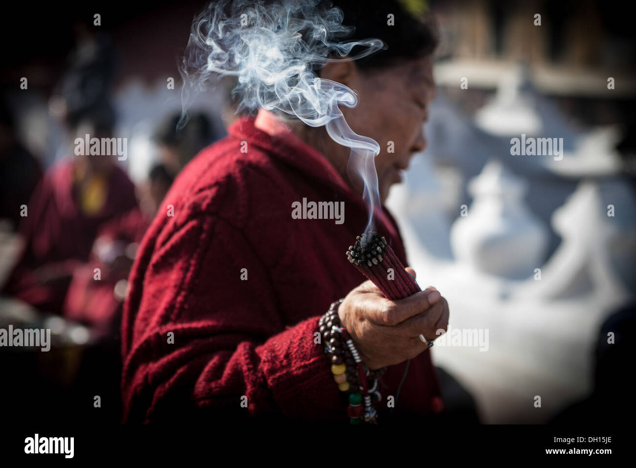 Eine Frau Wellen Räucherstäbchen auf den heiligen buddhistischen UNESCO-Weltkulturerbe von Boudhanath Stockfoto