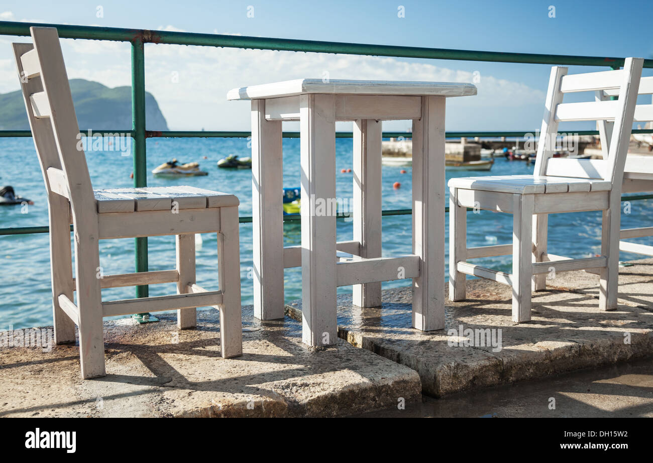 Weiße Holzstühle und Tisch stehen an der Adria-Küste in Montenegro Stockfoto