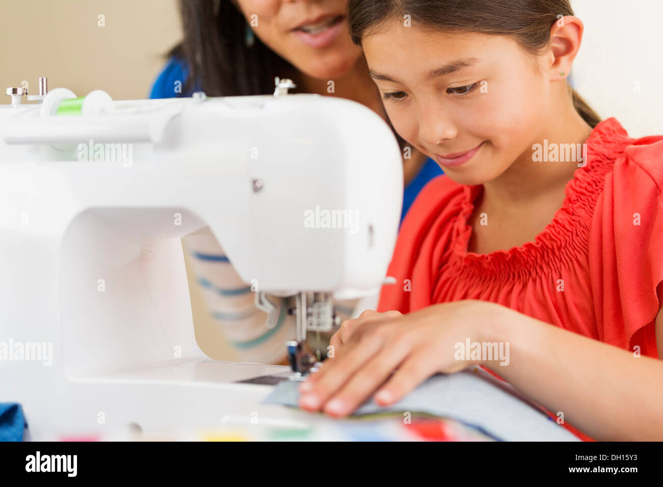 Mutter Lehre Mädchen um die Nähmaschine verwenden Stockfoto