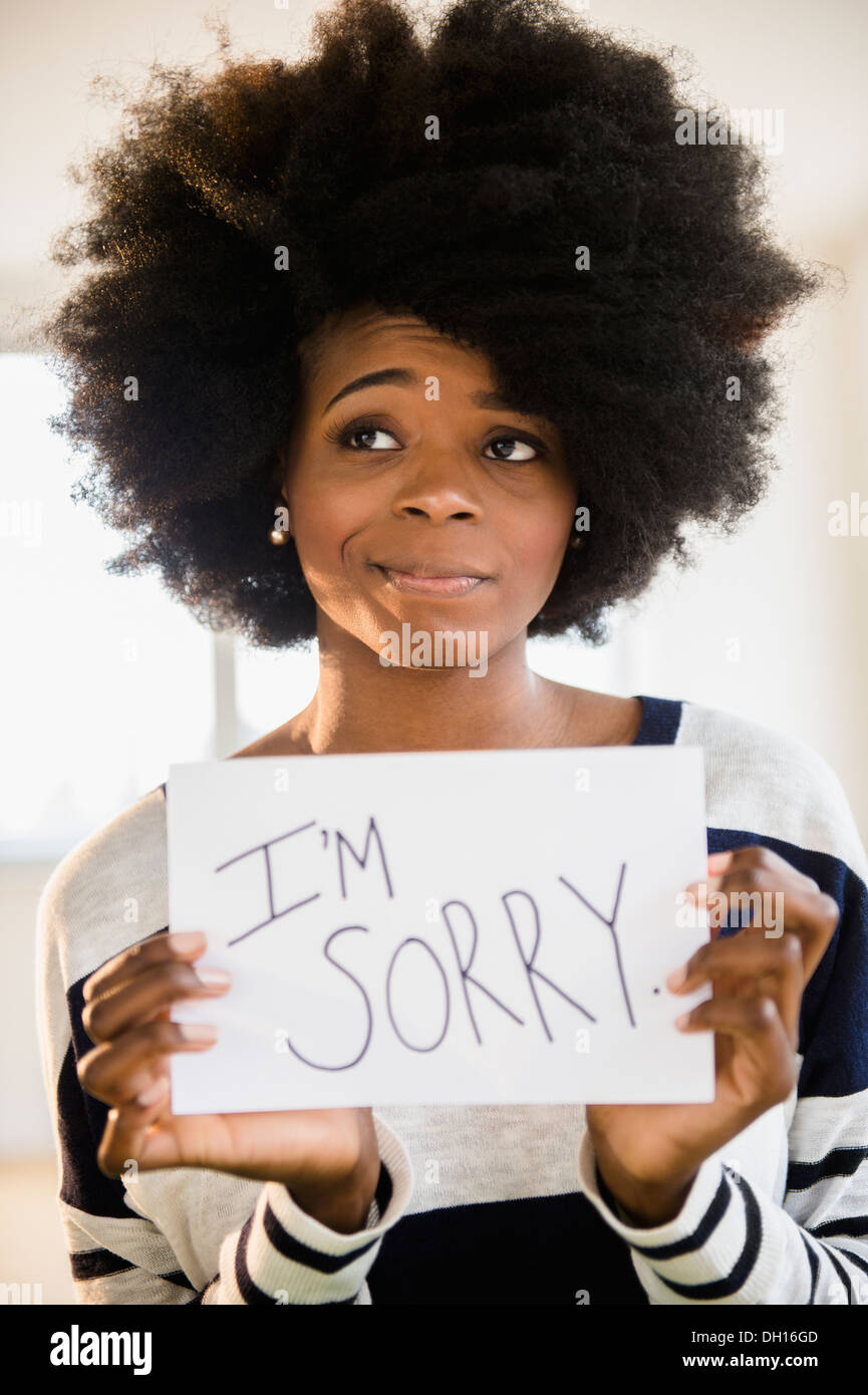 Gemischte Rassen Frau mit Schild "Es tut mir leid" Stockfoto