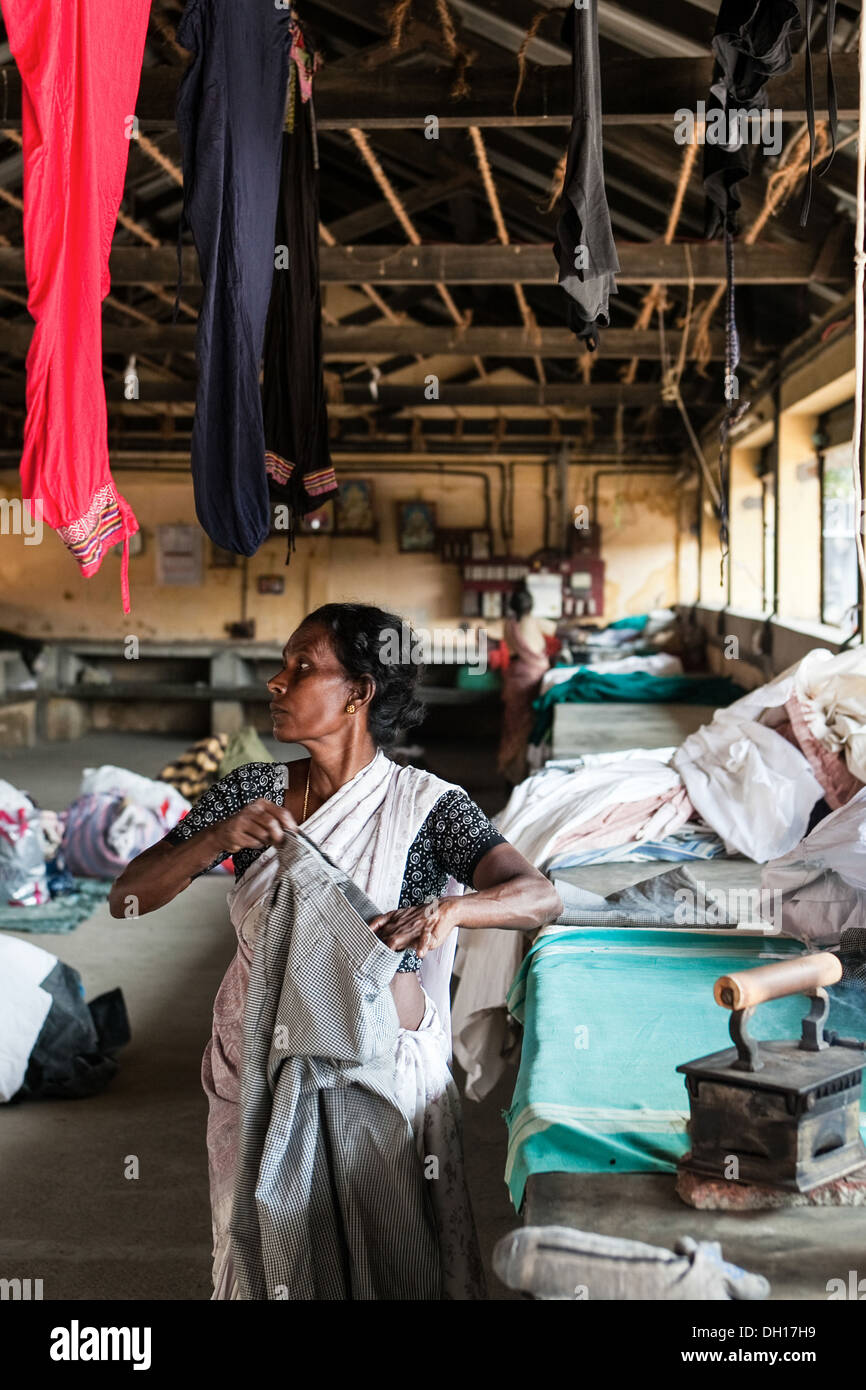 "Dhobi Waller" Wäscherei Dame an Cochin die riesigen Wäsche für Hotels und Einheimische, Bügeln von hand mit Kohle beheizt Eisen, Indien Stockfoto