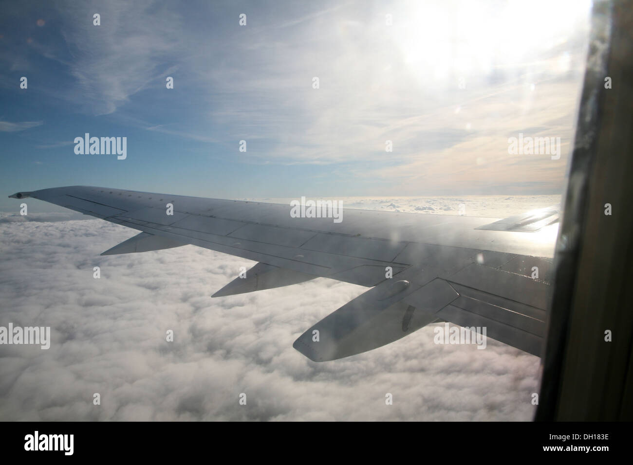 Auf der Suche Flugzeugfenster am Flügel und Wolken unter Stockfoto