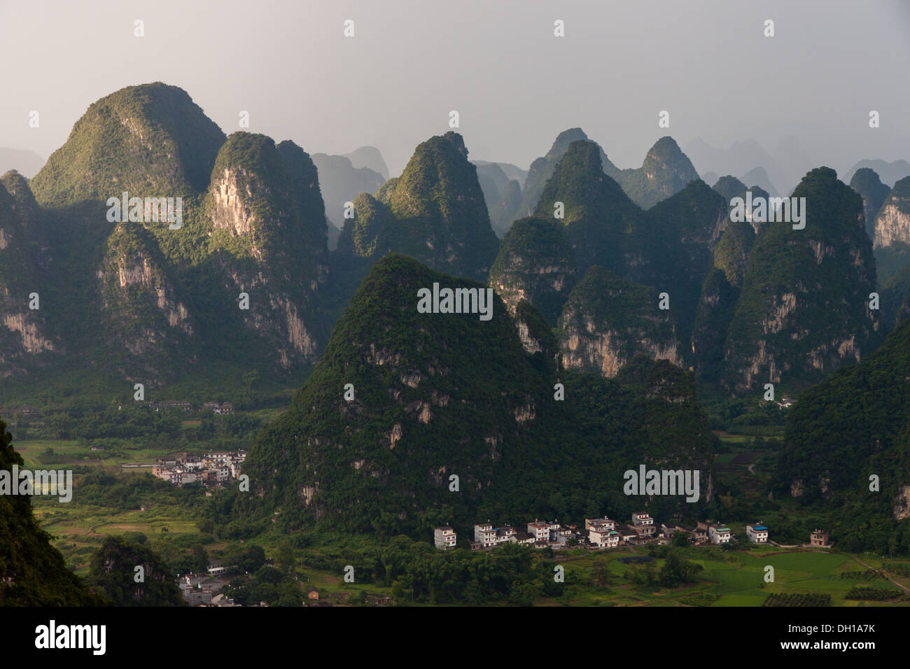 Ein kleines Dorf unterhalb Karst Peaks in Süd-China Stockfoto