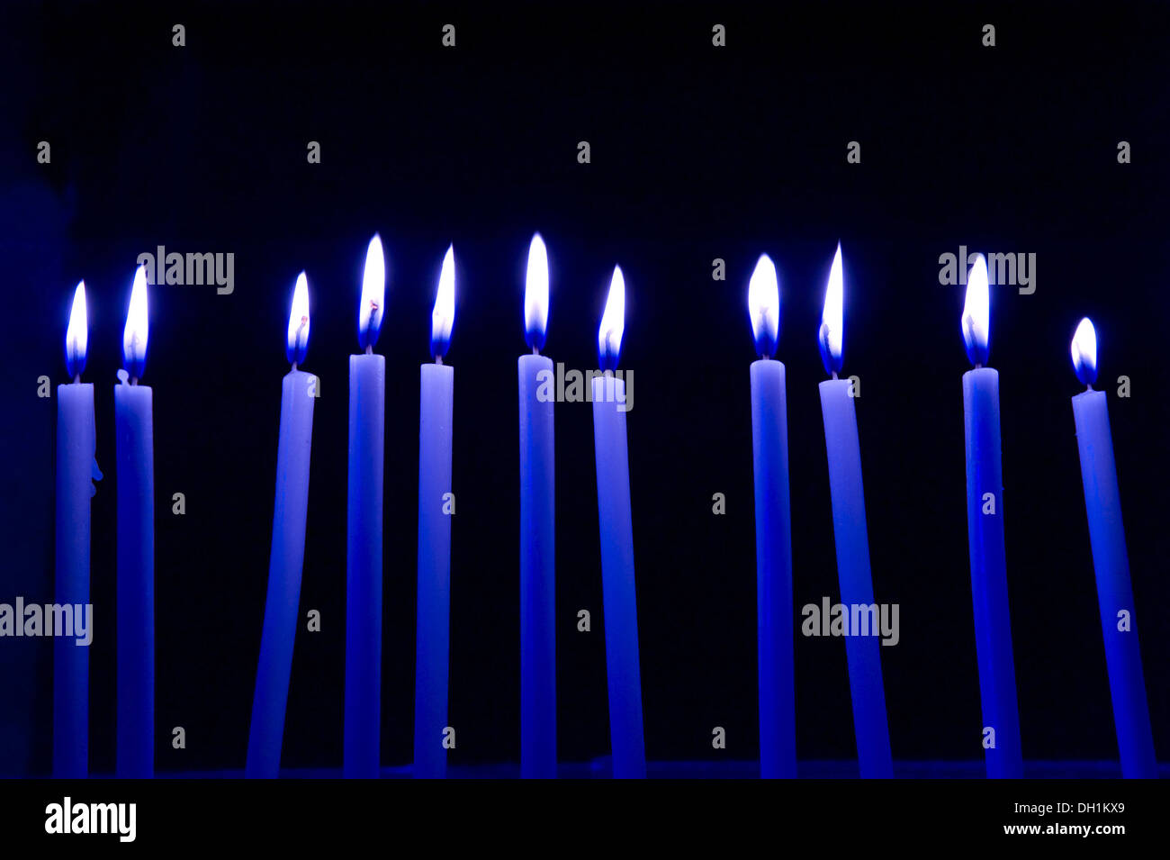 elf blaue Kerzen, brennende Flamme schwarzen Hintergrund Stockfoto